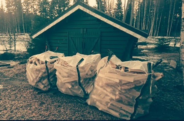 Polttopuusäkkejä varastorakennuksen edessä